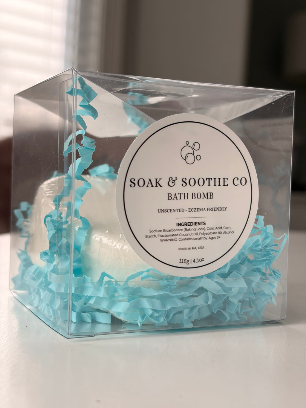 A clear boxed heart shaped white unscented, eczema-friendly bath bomb for sensitive skin, handpressed 4.1 oz